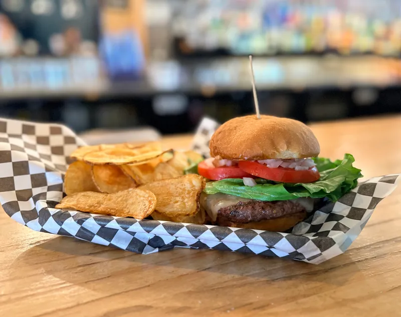 White Dog cheeseburger with lettuce, tomato and onion on a toasted bun, served with house-made kettle chips